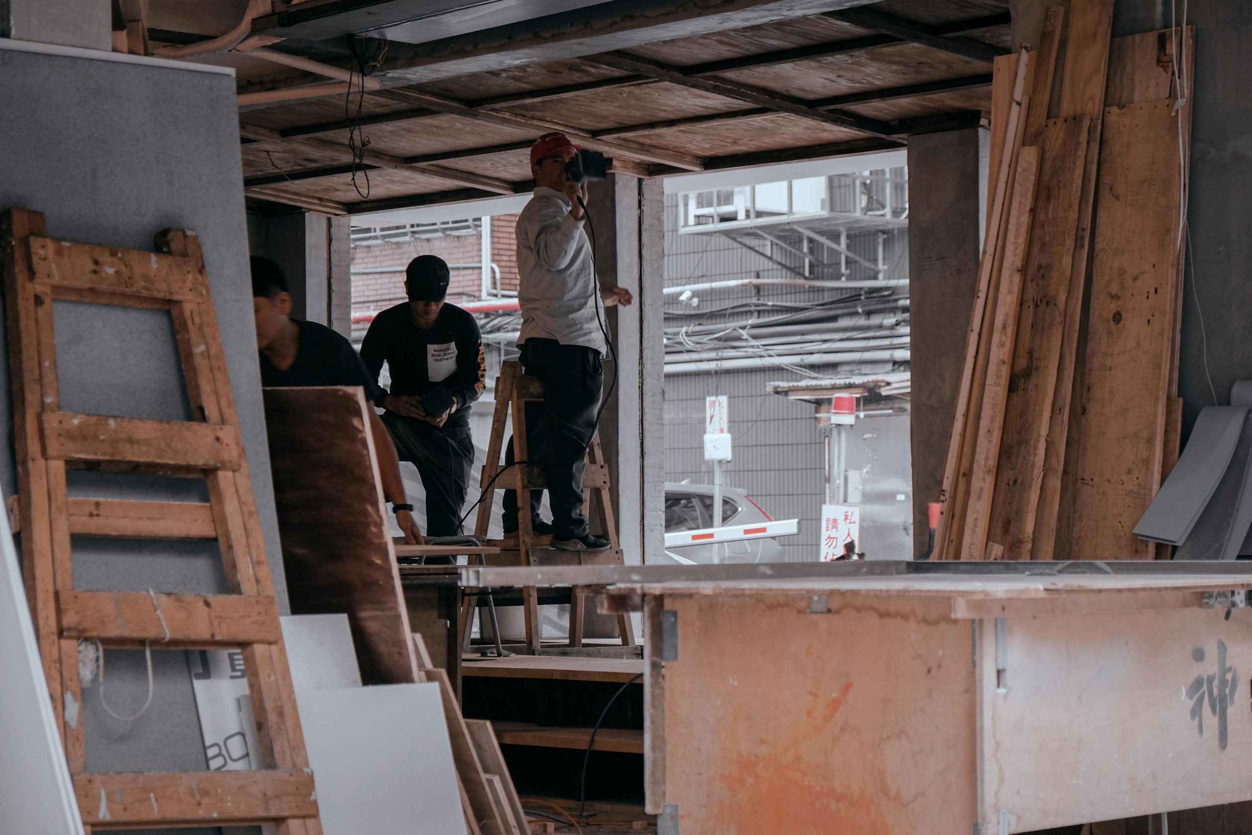 Workers engaged in carpentry inside a building under construction, showcasing teamwork and skill.